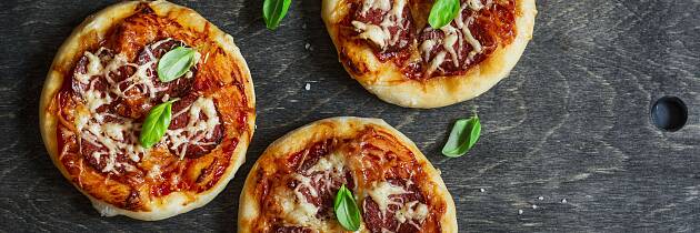 La barna pynte pizzaen sin selv med rask pizzasaus og salamipølse