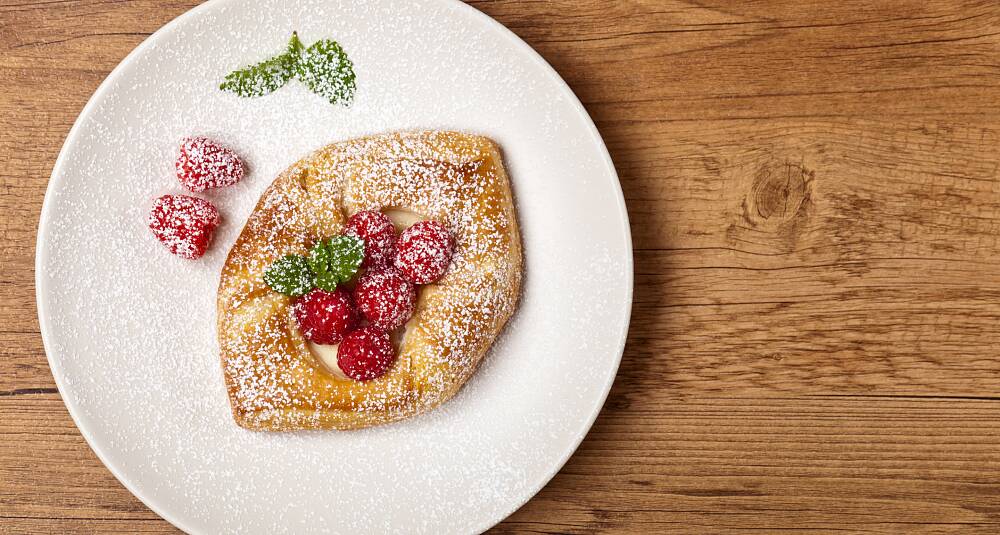 Butterdeig fylt med eggekrem og rips eller bringebær