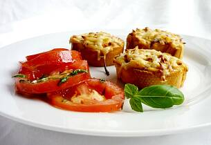 Tomatsalat med lun og sprø ridderost-crostini, saltkokte pinjekjerner og basilikum