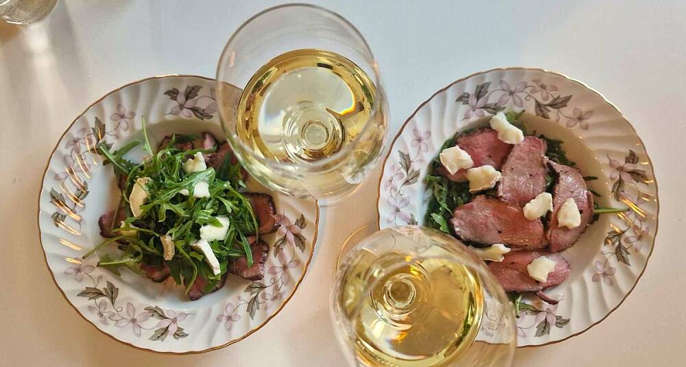 Leken kombinasjon av and og appelsin med perfekt vinfølge i glasset